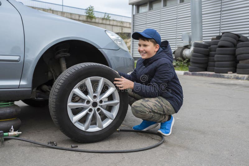 The Car Is At A Car Service Replacing The Wheels On The Car The Jack Holds The Body In A Raised Position With The Wheel Removed Stock Photo Image Of Business