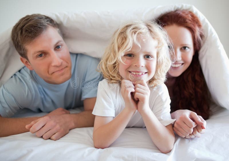 Boy with His Parents Under Bed Cover Stock Photo Image of family