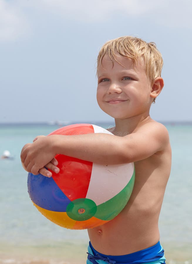 Boy holding ball on the beach