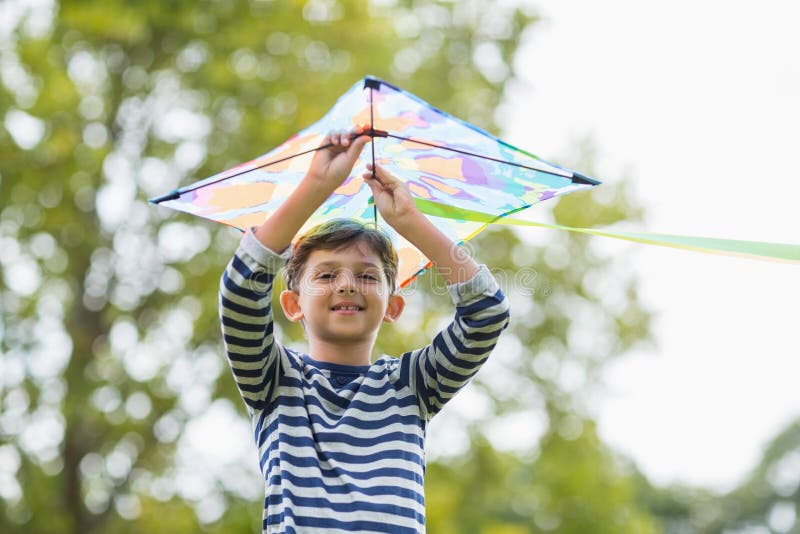 Boy holding a kite in park stock photo. Image of playful 77905384