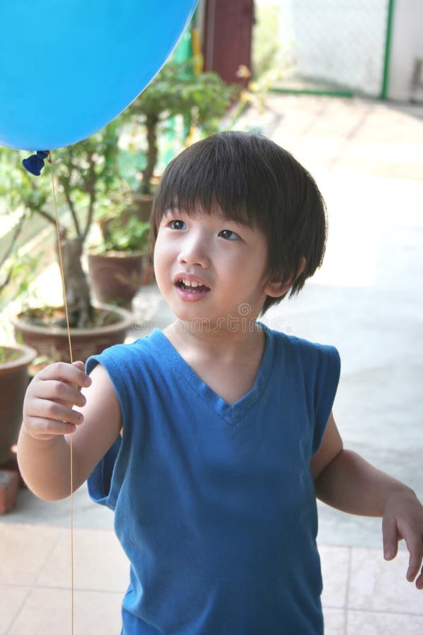 Boy holding & looking at balloon