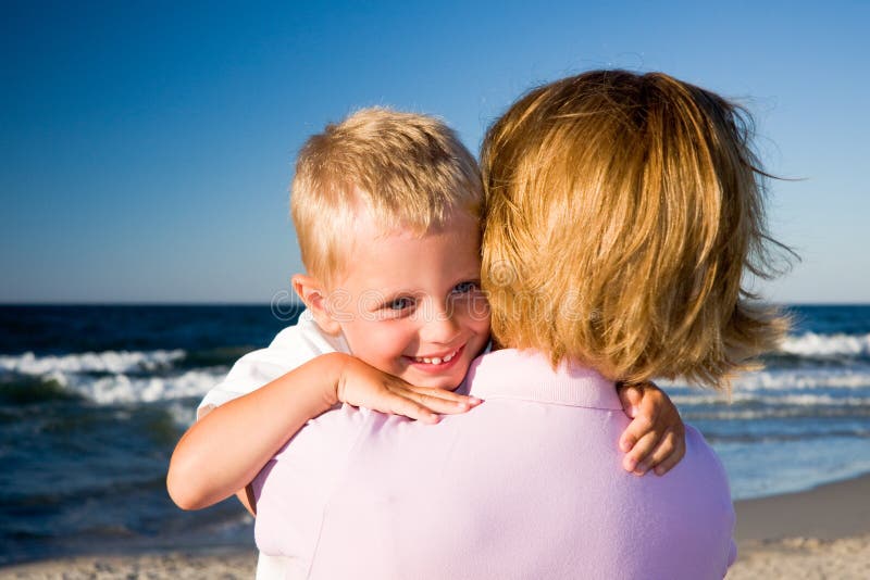 Boy hugging mother on beach