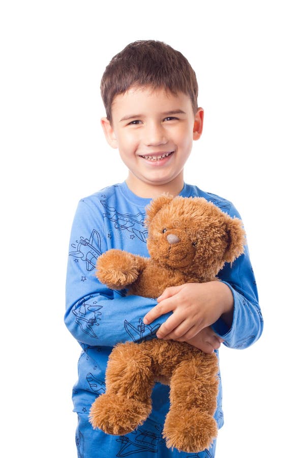 Cute boy in pajamas hugging a teddy bear royalty free stock images.