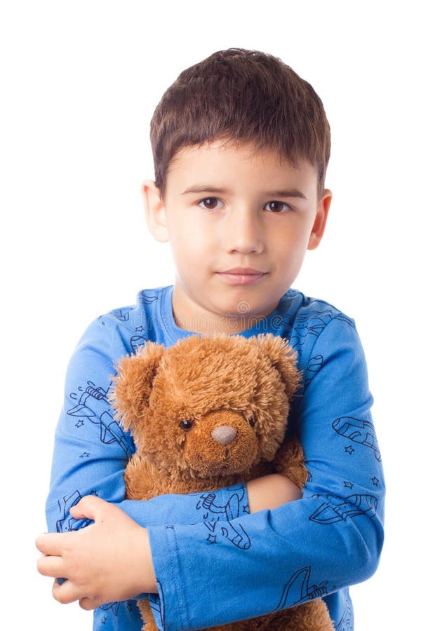 Cute boy in pajamas hugging a teddy bear royalty free stock photography.