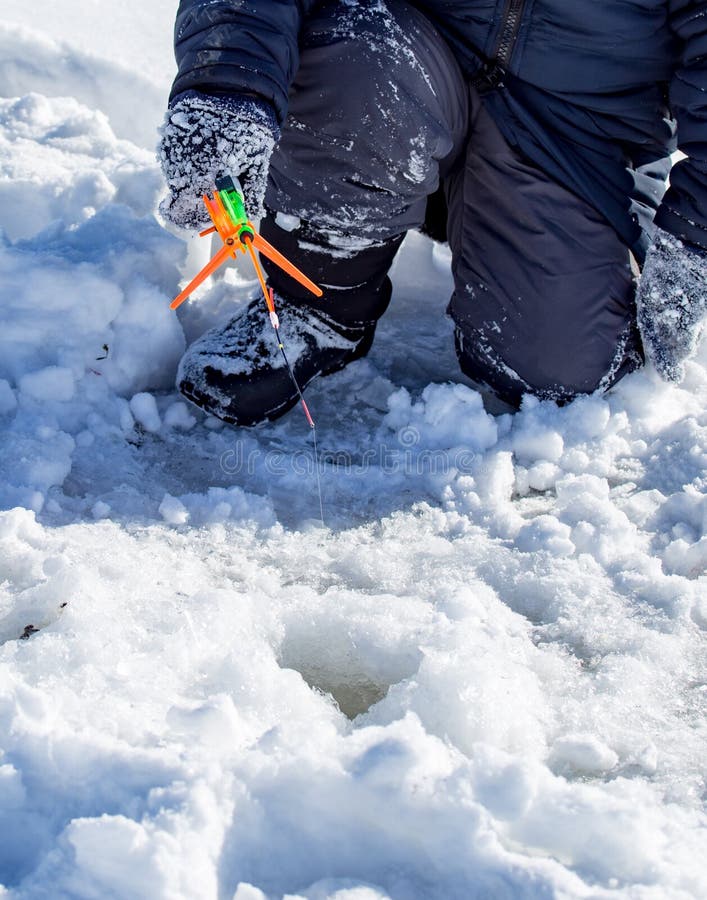 A boy on ice is fishing in the winter royalty free stock image