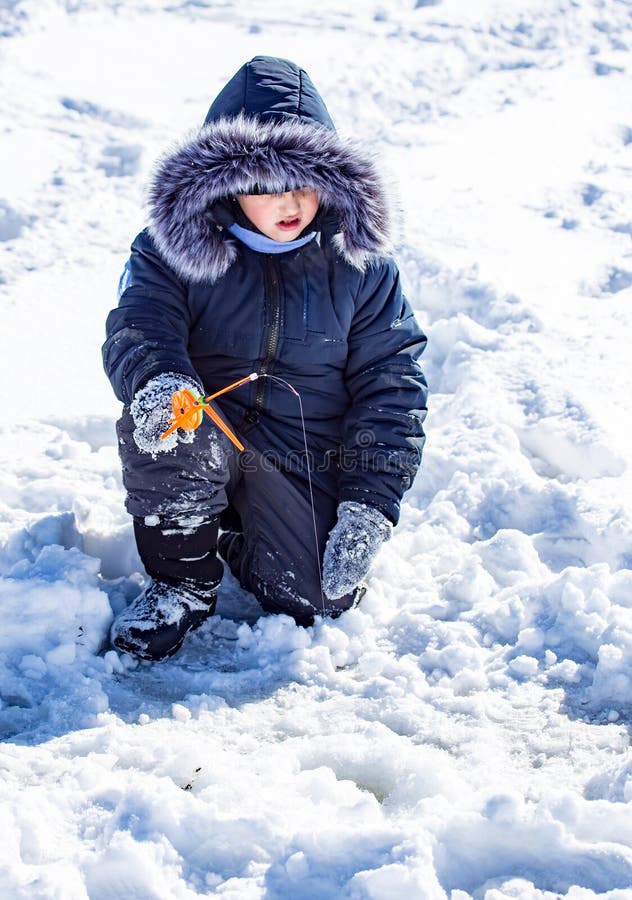A boy on ice is fishing in the winter stock image