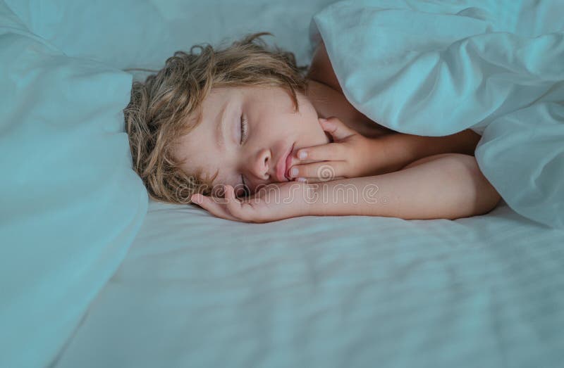 Boy Kids Sleeping in Pajamas on White Bed. White Bed. Stock Image