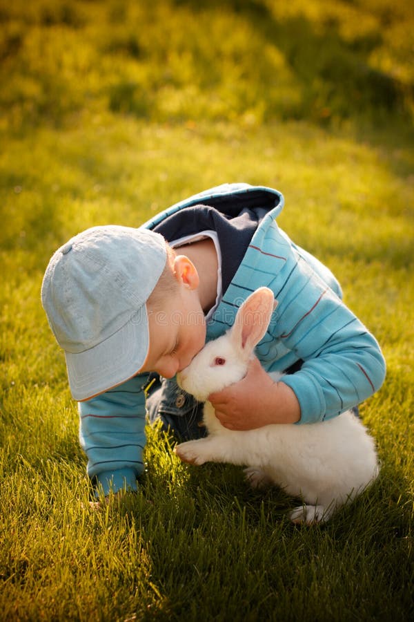 Un bambino di baciare un coniglietto, per i quali ha ricevuto come un regalo prima di orientale.