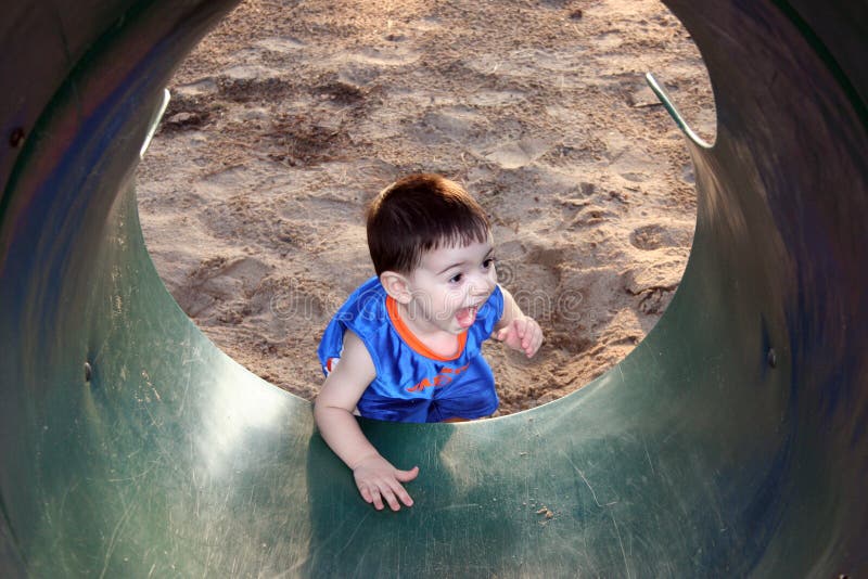Boy Laughing And Playing With The Slide