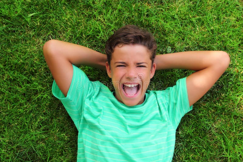 Boy laughing teenager laying green grass