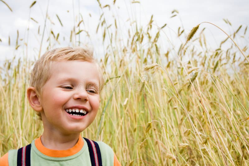 Boy laughing on wheat field