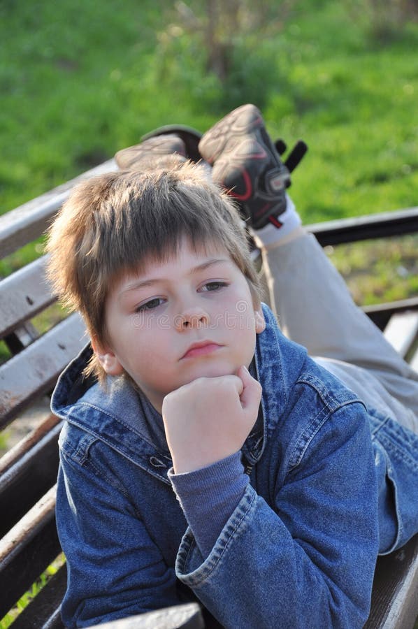 The boy lay on a bench stock image. Image of pensive - 19423237