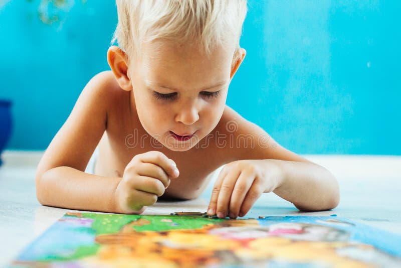 Boy learning how to solve a puzzle royalty free stock photos.