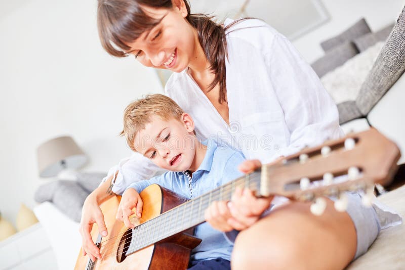 Boy learns to play guitar at home royalty free stock photo Boy learns to play guitar at home royalty free stock photo