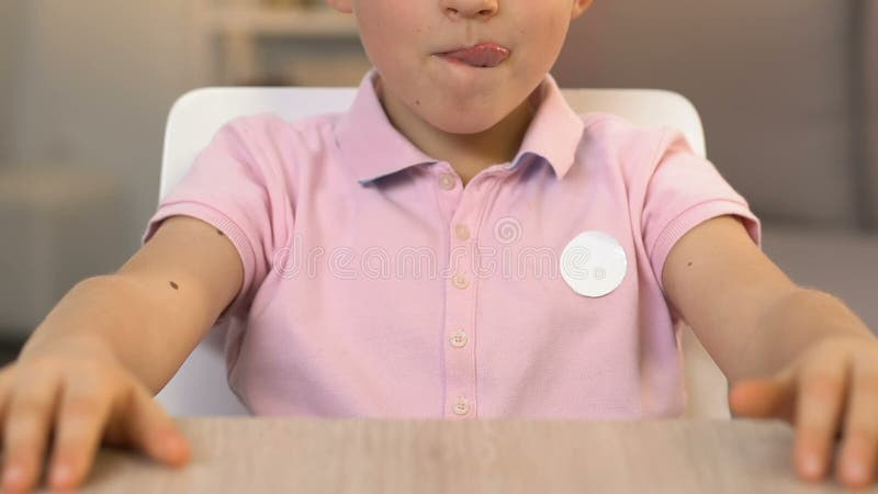 Boy licking lips, looking at tasty cake with love, unhealthy food for children