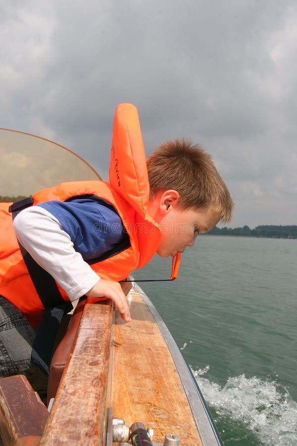 Boy In Life Vest Leaning Over Boat Railing Stock Image Image of
