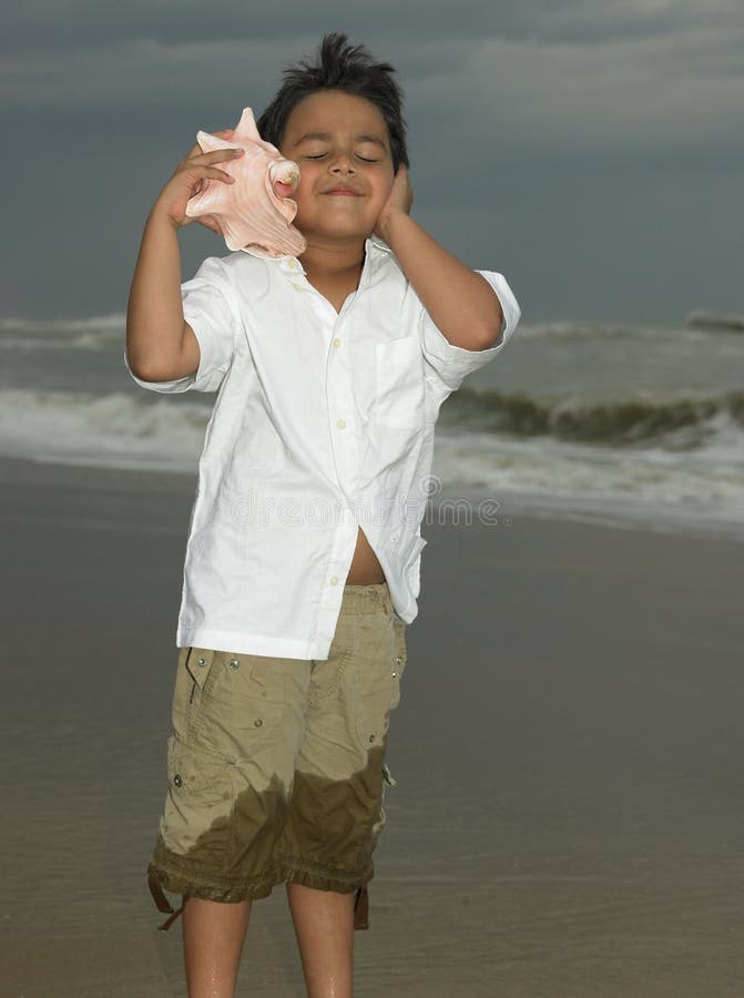 Boy listening to a conch