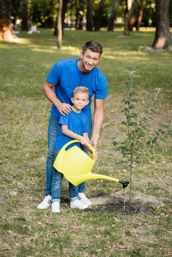 father and son digging ground in forest with shovels, ecology