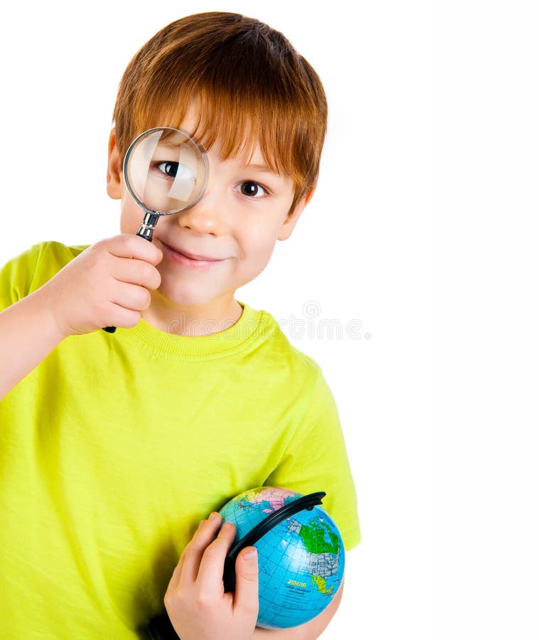 Boy looking through a magnifying glass stock image