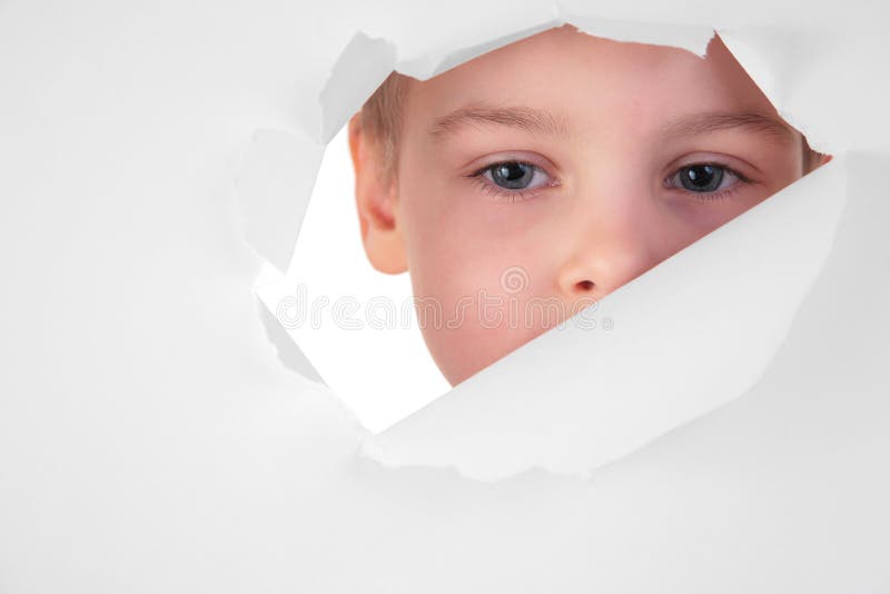 Boy looks in a hole in a sheet