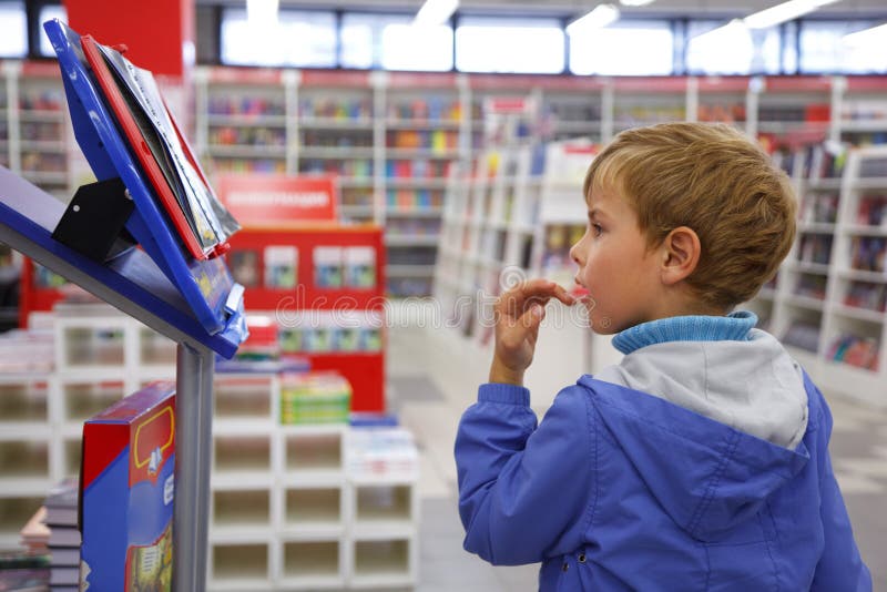 Boy looks at show-windom, bookshop