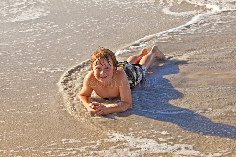 Boy lying at the beach and enjoying the sun