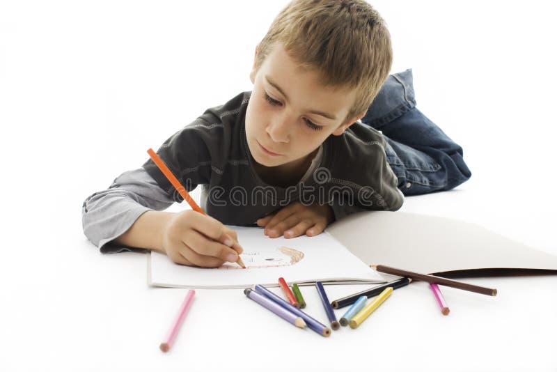 Boy lying on the floor and drawing on the paper stock image
