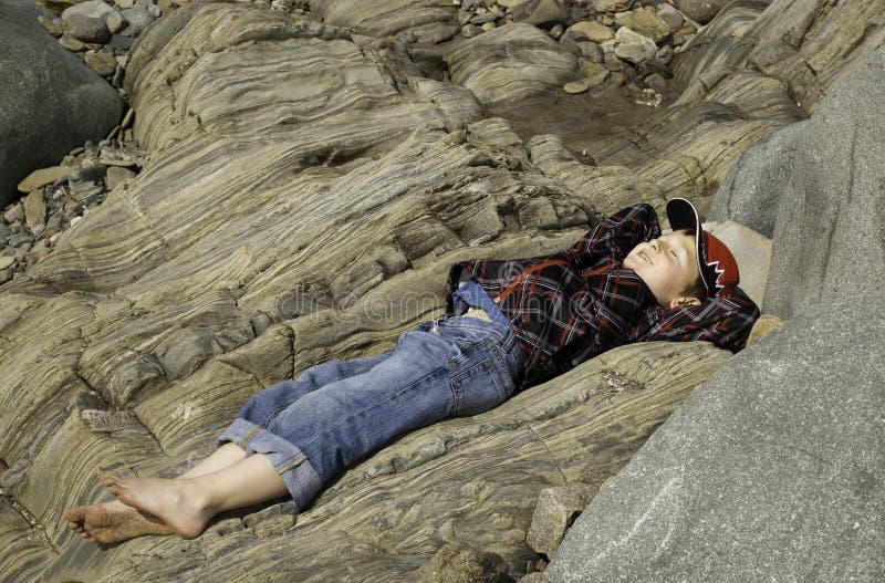 Boy Lying on Rock on the Beach Stock Photo Image of sandy, peace