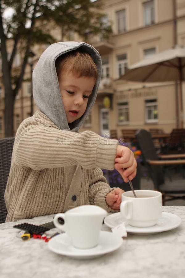 Boy Drinking Tea with a Spoon Stock Photo Image of white, outdoor