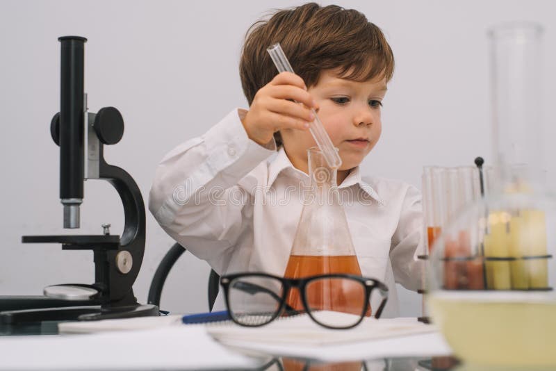 The Boy with a Microscope and Various Colorful Flasks on a White ...