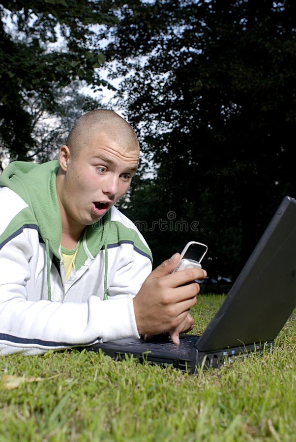 Boy with notebook and cell phone in park