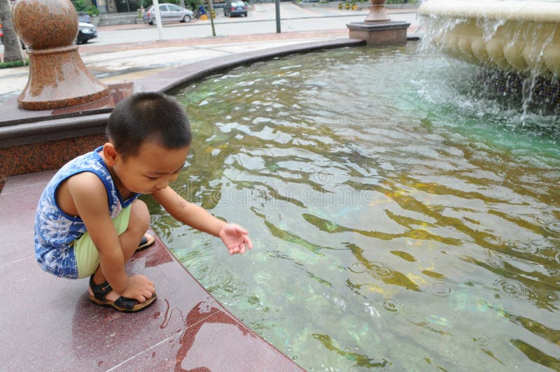 The boy play with fountain water