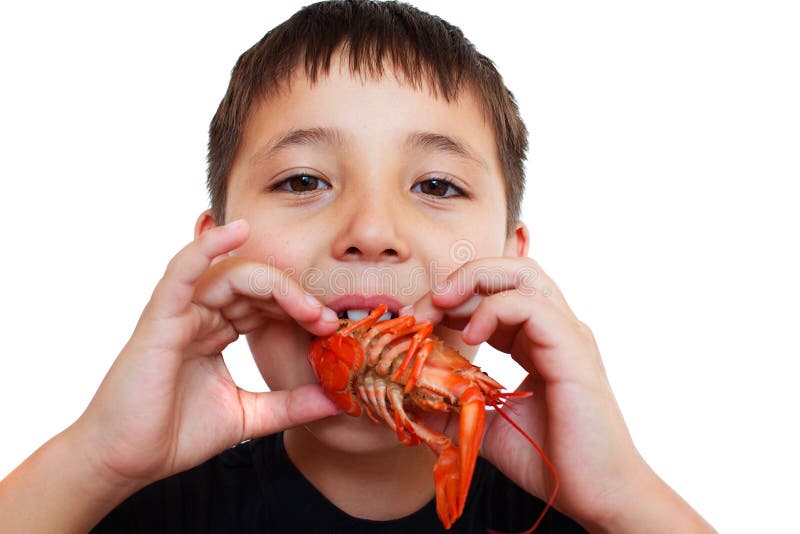 boy playfully eating crayfish