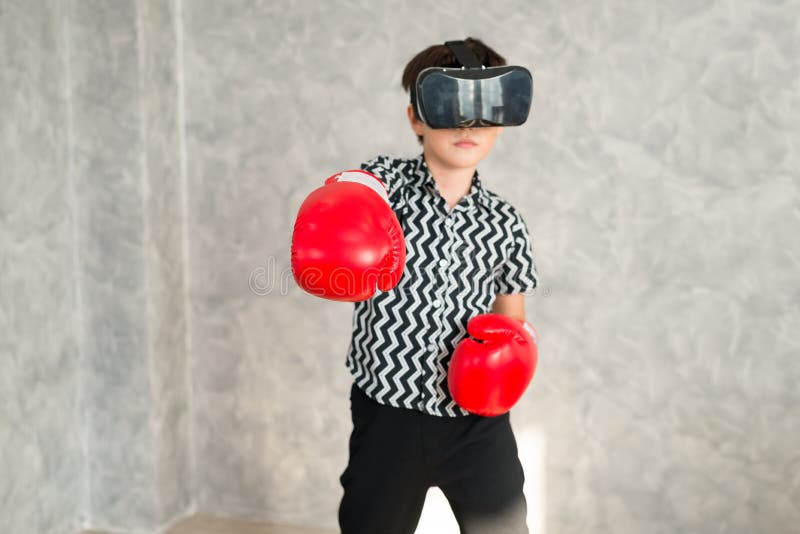 A Boy is Playing Boxing Game with 3D Virtual Reality Headset. Stock