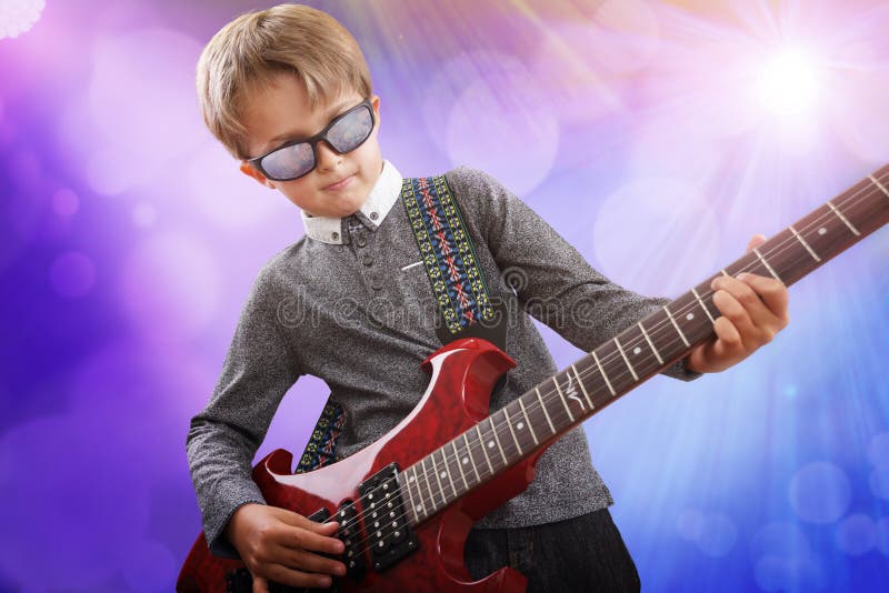 Boy playing electric guitar in talent show on stage