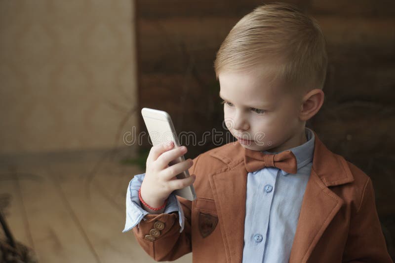 Boy playing in the game on the phone lying in bed next toy white teddy bear stock images Boy playing in the game on the phone lying in bed next toy white teddy bear stock images