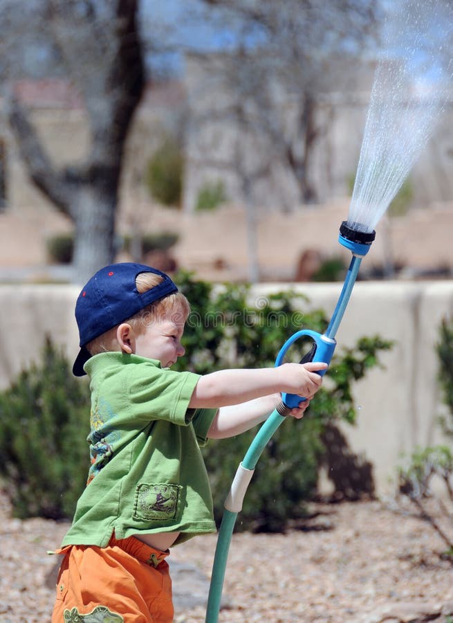 Boy playing with garden hose