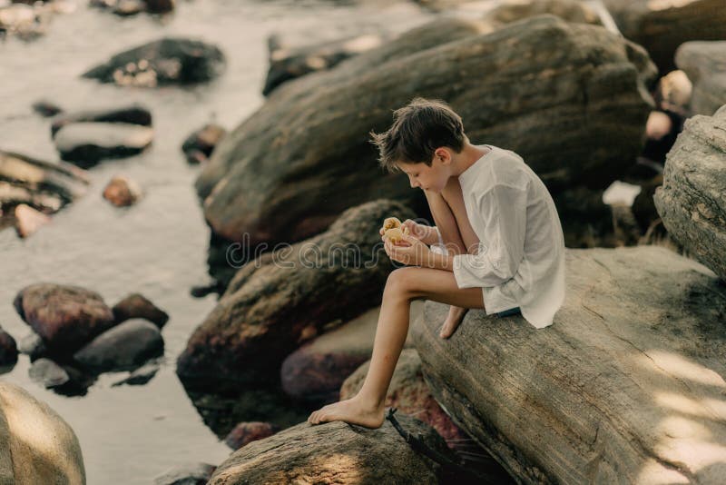 The boy is playing on rocks