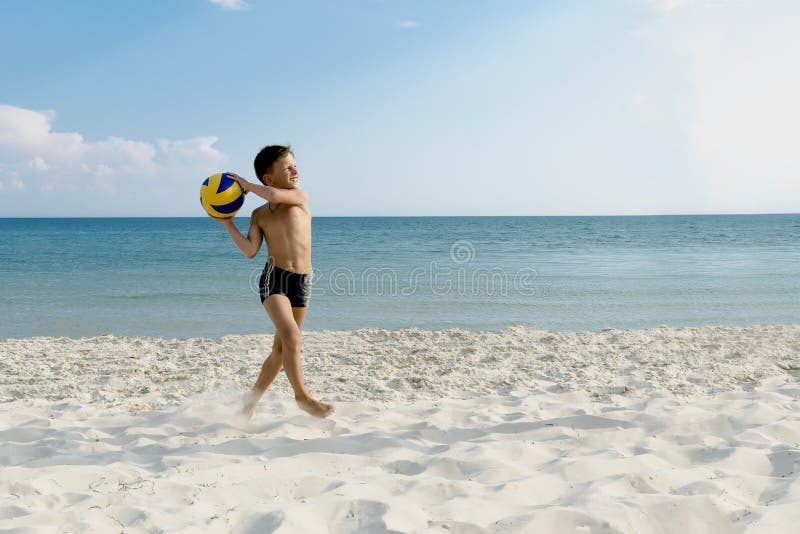 Boy playing and running ball of valleyball at the sea beach