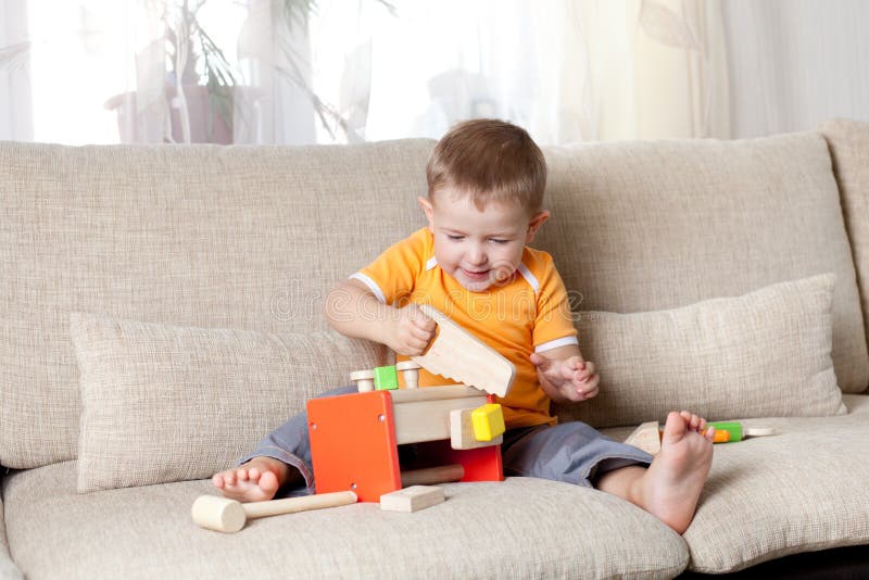 Boy playing with wooden building toys at home