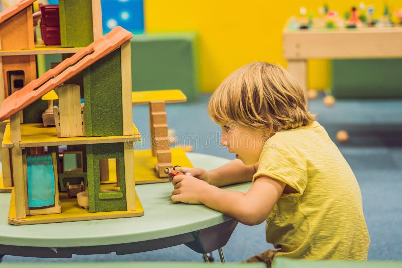 Boy playing with wooden house in kindergarten royalty free stock image Boy playing with wooden house in kindergarten royalty free stock image