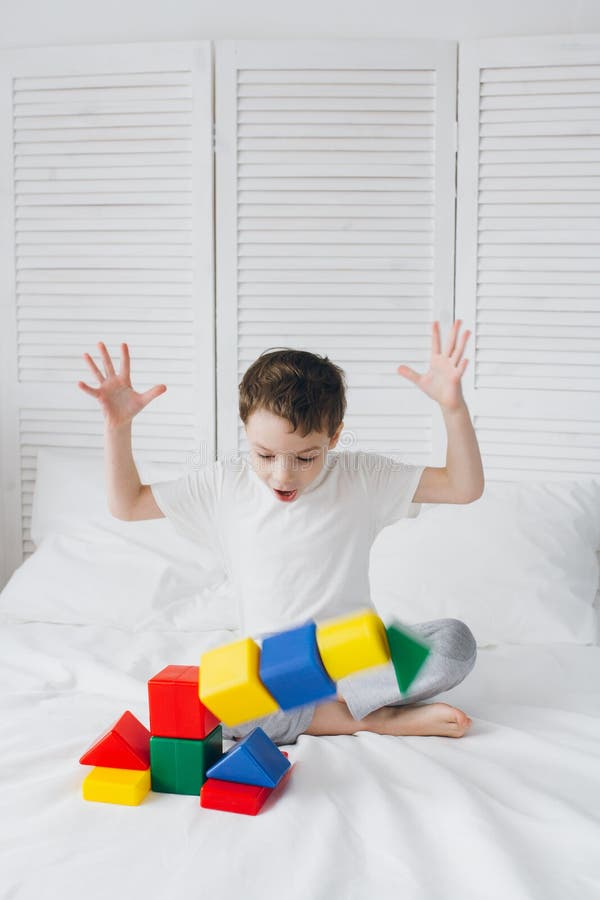 Boy plays and builds a tower of colorful plastic cubes stock photography Boy plays and builds a tower of colorful plastic cubes stock photography