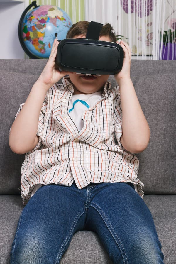 Boy Plays with Virtual Reality Glasses, Indoors. Digital Virtual