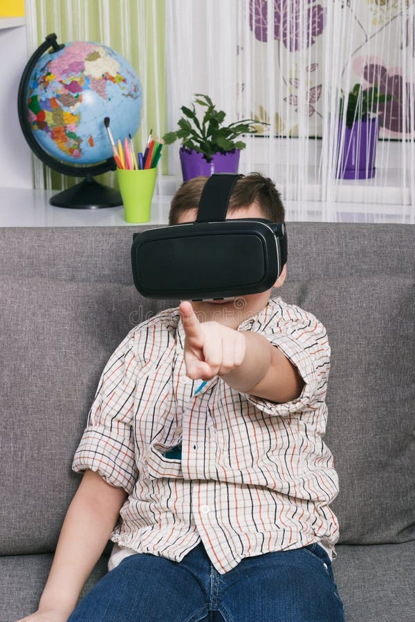 Boy Plays with Virtual Reality Glasses, Indoors. Digital Virtual