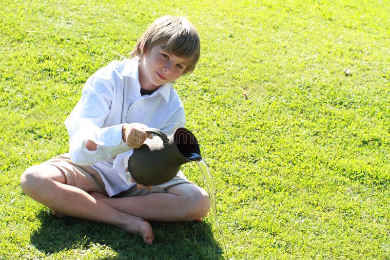 Boy pooring water from a pitcher