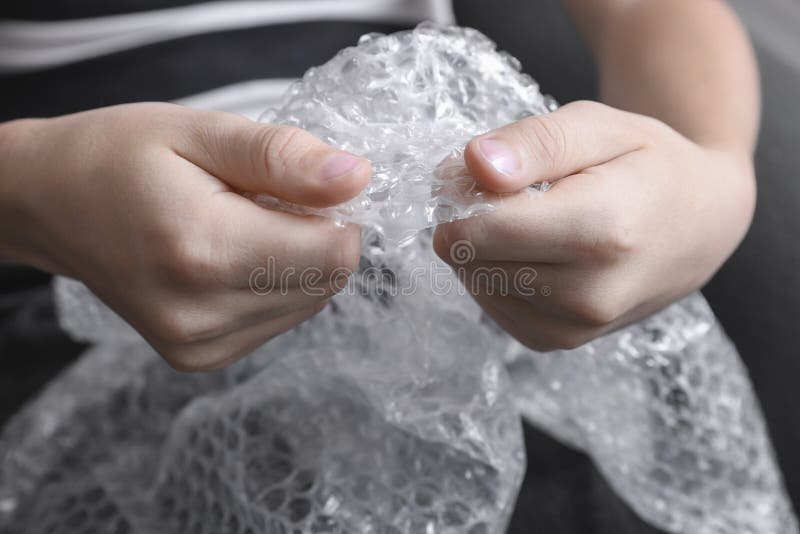 Boy Popping Bubble Wrap Indoors, Closeup. Stress Relief Stock Image