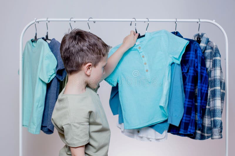 Boy Preschooler Standing by the Hangers, Racks Up Clothes, and Chooses ...