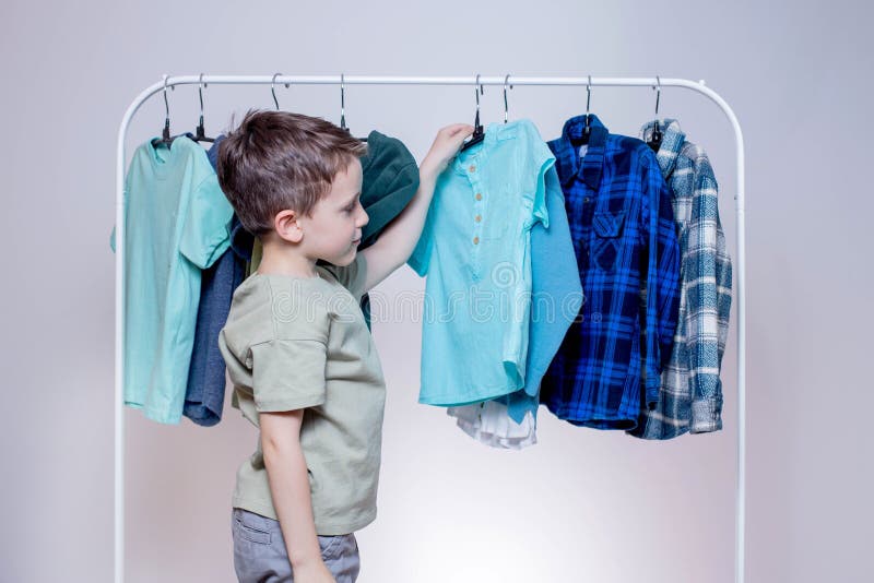 Boy Preschooler Standing by the Hangers, Racks Up Clothes, and Chooses ...