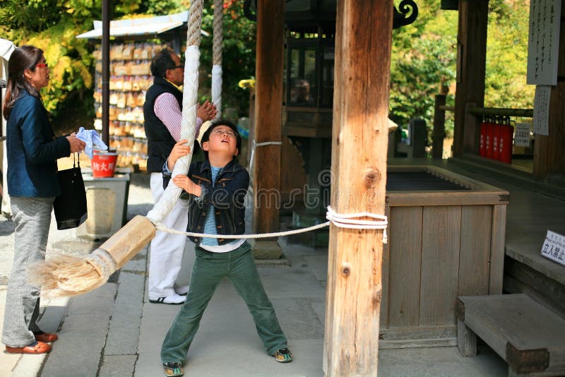 Boy Pulls Rope To Ring a Bell at Kinkakuji Temple Editorial Image