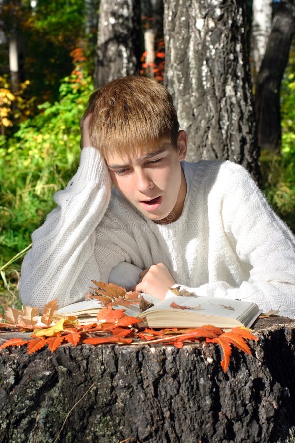 Boy reading outdoor stock photography